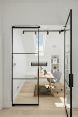 Office | Double glass door with black metal surround, white walls and millwork with white oak hardwood floor.