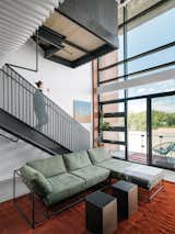 Chioco says they “treated the stairs and structural beams as design elements, painting them a dark color to contrast with everything else to visually tie the space together.”