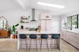 The kitchen is painted in Setting Plaster by Farrow and Ball. The Fibre bar stools and Ambit pendants are from Muuto.