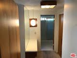 The master bath was very small and dark, enclosed by wooden paneling, a popcorn ceiling, and harsh lighting.  Photo 12 of 17 in Before & After: An Enterprising Couple Revive a Dated Midcentury in the Hollywood Hills