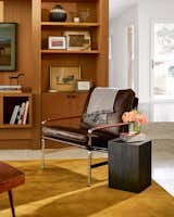 A cozy leather chair anchors the living room and adds traditional flair. The bookshelves are decorated with personal items, a Samsung television that looks like a piece of art, and a miniature horse statue Simon bought in Round Top.