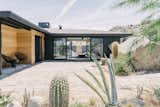 The couple added a coat of black paint and cedar siding to give the home a cleaner, more modern look. "The house already had wide and low eaves, providing protection from the sun, and we added new spray-foam insulation, so the black exterior actually does not pose too much of an issue with the desert heat," she says. A new Cor-Ten steel fence blocks the view of the neighbor's roof, but doesn't interfere with the landscape. 