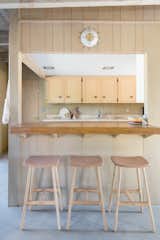 In the kitchen, Lewis was in awe of the beautifully restored cabinetry and wooden details, and wanted to leave things as is. She then added barstools from Article. 