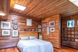 Bedroom, Bed, Storage, Night Stands, Light Hardwood Floor, and Ceiling Lighting Locally milled wood clads the interior of this massive artist's compound.   Photo 5 of 10 in Renowned Artist Emile Norman’s Sensational Big Sur Home Lists for $2M