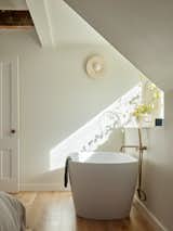 In a primary suite, a free-standing tub and new dormer window lend an air of European elegance. "<span style="font-family: Theinhardt, -apple-system, BlinkMacSystemFont, &quot;Segoe UI&quot;, Roboto, Oxygen-Sans, Ubuntu, Cantarell, &quot;Helvetica Neue&quot;, sans-serif;">That planning wasn't tracditional and allowed me to achieve what they wanted,