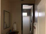 The secondary bathroom once had the same design as the primary bathroom when it came to materiality.