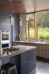 The home's interiors are linked with the landscaping, yet are a spot to showcase personality as well. In the kitchen, navy cabinetry pairs with terrazzo countertops.