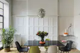 Existing paneling was painted Chantilly White by Benjamin Moore.  Vintage PH Snowball hangs over a custom dining room table and vintage Eames chairs.  Photo by Kate Glicksberg.