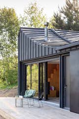 Outdoor, Trees, Front Yard, and Wood Patio, Porch, Deck The wave shape of the roof.  Photo 8 of 15 in COSMOS house  that lifts your spirit by Yaryna Bakhovska