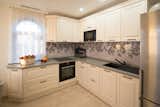 Kitchen, Refrigerator, Microwave, Range Hood, Cooktops, Ceramic Tile Floor, White Cabinet, Glass Tile Backsplashe, Engineered Quartz Counter, Range, Drop In Sink, Recessed Lighting, Wall Oven, and Accent Lighting  Photo 9 of 18 in Tree of Life by Natalia Beleva