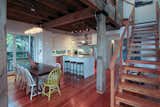 Living Room, Light Hardwood Floor, and Pendant Lighting The stairs and exposed timber frame were custom crafted from reclaimed heart pine salvaged from an old SC warehouse. The home utilizes modestly sized spaces for a total of 2600sf.  Photo 7 of 12 in Sharp Home by Amber Allen