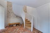Staircase and Wood Tread A new curling staircase accommodates the new layout. Formerly the staircase had been near the front entrance.  Photo 7 of 11 in An Architect’s Weekend Home Along the French Riviera Borrows Stones From Ancient Ruins