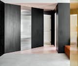Stainless-steel doors and a pink triangle threshold create a unique entryway to the bedrooms.