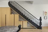 Henry Built cabinetry fits neatly beneath the upward staircase, taking over the area leftover from removing the basement stairs.