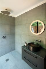 The bathroom of Champa is tiled and opens to an outdoor shower.