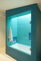 View of the shower/tub with skylight above. The glass mosaic tiles glow in the sunlight, adding color and vibrancy to the room.