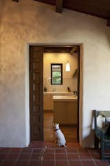 Entry Vestibule to the Kitchen  

Across the entry vestibule from the living room is the new kitchen- part of the addition to the original house. A pair of paneled wood doors can close down the kitchen and the living room from the entry vestibule. But when opened, it creates a large continuous connection through both sides of the house.

The kitchen is clearly more modern than the original house, a fact Dutton Architects did not want to hide.