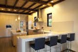 View of the kitchen showing the eating counter. The caesarstone countertop also continues up to be a monolithic backsplash.