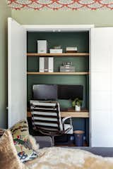 One of two home offices was built into the existing second bedroom closet space and features a gorgeous  white oak desktop and two overhead floating shelves. To the right, an electrical panel is given a stylish upgrade with a painted wood and cane box cover.