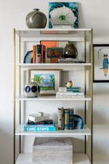A West Elm bookshelf is styled with the owners' eclectic collection of books, ceramics, and other decorative pieces.
