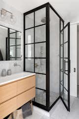 Glass shower in marble bath.
