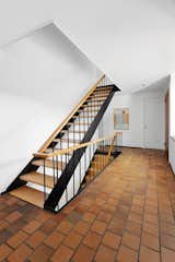 The steel-and-wood stairway runs sideways in the home, also providing a buffer between the front windows on right and the remainder of the home. 