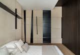 Inspired by Malevich paintings, the lines and various shapes of the paintings extrude out, taking the third dimension and becoming diagonal bookshelves, an oblique niche with tilted shelves, a sliding door and a bespoke handle, wrapping around the whole bedroom.