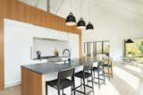 Kitchen, Granite Counter, Light Hardwood Floor, Ceramic Tile Backsplashe, Refrigerator, White Cabinet, Pendant Lighting, Range, and Undermount Sink Kitchen  Photo 12 of 36 in The Slate House by Hygge Design+Build