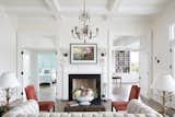 Old Grove estate formal living room with custom hand carved fireplace, disappearing doors, and coffered ceilings. To the right are the doors opening up to the expansive back porch overlooking the Florida riverfront.