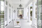 Old Grove estate Southern back porch overlooking the Florida riverfront featuring lanterns, detailed columns, grand staircase. Doors open on both sides of the porch into the kitchen/dining area as well as the music room. 