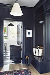 Navy mud room with exquisite build in detailing featuring a Dutch door into Laundry room with painted floor.