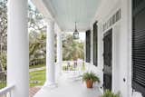 Old Grove estate front entry porch with gas lanterns, Timberlane shutters, detailed columns, brick staircase, and traditional southern Haint Blue ceiling. 
