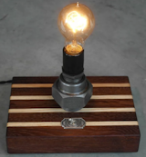 Ash Wood & Roasted Oak Steel Union Lamp.
This timeless Todd Alan Woodcraft creation uses two of our favorite woods, dark Roasted Oak and the light beautiful Ash.

To Purchase: 
https://toddalanwoodcraft.com/collections/lighting/products/ash-wood-roasted-oak-steel-union-lamp-only-2-available

These boards are created from the high quality cast-off wood from our cutting board pieces. They come together to make this striking base.  We tie the lamp together with vintage style reproduction ceramic sockets topping some awesome reclaimed Steel cast unions we picked up from an estate sale.  

Perfect for bedside, family room or even in the office! These have an antique look made with modern craftsmanship and feature a toggle switch with a early 1900s relic style On/Off switch-plate

Your space will glow of a vintage look with the warm, rich, pleasing feel of an incandescent Edison bulb. 

This light comes with a black braided industrial era reproduction cloth cord and reproduction antique plug. Lights come featured with inset low profile non-skid feet attached to the bottom.