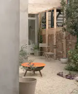Just outside the kitchen's rear entry, Benjamin Hale Architects created a pergola that aligns to the ceiling joists that top the wash/prep area inside.
