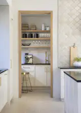 Butler's pantry adjacent to the kitchen accompanied with additional sink, beverage station and storage.