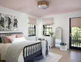Bedroom with 6 over 6 double hung windows and door to the second story balcony.