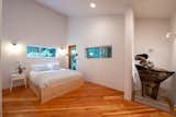 Main bedroom with custom set windows to join the forest with the room.