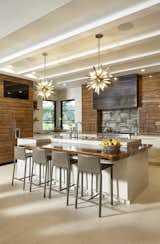 Kitchen, Wood Counter, Range, Refrigerator, Cooktops, Range Hood, Limestone Floor, Stone Tile Backsplashe, Undermount Sink, Accent Lighting, Recessed Lighting, Pendant Lighting, Wood Cabinet, and Marble Counter Kitchen and Island  Photo 7 of 19 in The Bridges House by Virginia Pizzi