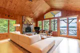 Open plan living area overlooking the lake with native stone fireplace and Andersen windows.