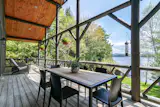Covered porch overlooking the water with Room and Board Montego table and Bellini dining chairs.