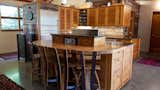 Kitchen, Concrete Floor, Wall Oven, Wood Backsplashe, Refrigerator, Accent Lighting, Wood Counter, Recessed Lighting, Dishwasher, Stone Counter, Drop In Sink, and Wood Cabinet Kitchen  Photo 6 of 34 in The Palimpsest House by Tara Lord