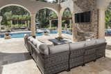 A comfortable all weather wicker sectional by Patio Renaissance allows for ample seating in front of the Heat n Glo Palazzo fire place. The outdoor living room overlooks the pool.