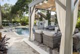 Privacy appears effortless thanks to clever design by Ryan Hughes Design Build. Thoughtful landscaping combined with the raised water feature wall offer privacy that’s unobtrusive and flows perfectly with the design. Lush landscaping provides a pleasing backdrop to the raised patio that’s perfectly situated alongside the pool in a spot that offers both sun and shade as the sun moves across the yard.