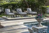 Clean-lined and comfortable artisan handcrafted cast aluminum chairs and ottomans from the Legend collection by CASTELLE flank the sophisticated centerpiece spa and sit atop the pool deck’s sleek, cool neutral toned tiles.