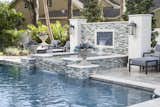 Elegant cascades of water at two levels draw the eyes and ears to the gracious elevated spa with hand-tiled water feature wall.  A graceful waterfall flows from Vidrepur tiles in clean and classic blue at the apex of this multi-tiered spa water feature, custom designed and built by Ryan Hughes Design.
