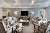 Plush neutral seating from collections by Ambella, Tomlinson and CtH create a cozy place for catching a game or a movie.  A modern inspired coffee table of metal and stone perfectly complements the seating.  