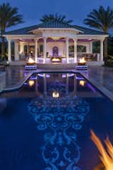 At the end of one of the home’s pools is a pavilion that matches the motif of the home with pillars and old-world style and holds an outdoor kitchen with its own water fall.  The inlaid tile in the pool is spectacular in design alone; but even more so with the addition of the 24 carat gold elements incorporated in Hughes’ creative vision.  