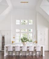 This modern kitchen and counter dining area are the perfect setup for a homeowner who loves to cook and entertain; whether a large crowd or an intimate family gathering.  From the uniquely shaped Design Master chairs to the modern look of the Visual Comfort lighting, this area, with its dramatic ceiling height and spectacular window design, is a welcoming attention-getter.  