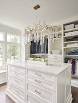 Bathed in sunlight from the large window expanse, the master bedroom closet speaks to the amount of detail the Allen and James design team brought to this project.  An amazing light fixture by Visual Comfort delivers bling and a wow factor to this dressing retreat.  Illumination of the classic cabinetry is also added with a shimmering  white finish.  