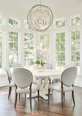 The breakfast area adjacent to the kitchen did not veer from the New Traditional design of the entire home.  Elegant lighting and furnishings were illuminated by an awesome bank of windows.  With chairs by Hickory White, table by Iorts and lighting by Currey and Co., each piece is a perfect complement for the gracious space.